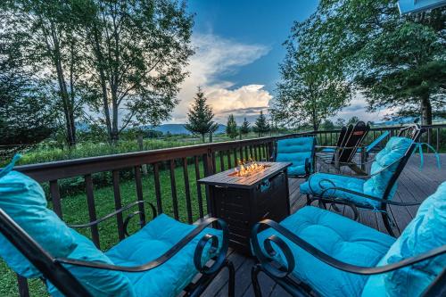 a deck with chairs and a table with a fire pit at Panorama Point - Gorgeous views, hot tub, theater in Davis