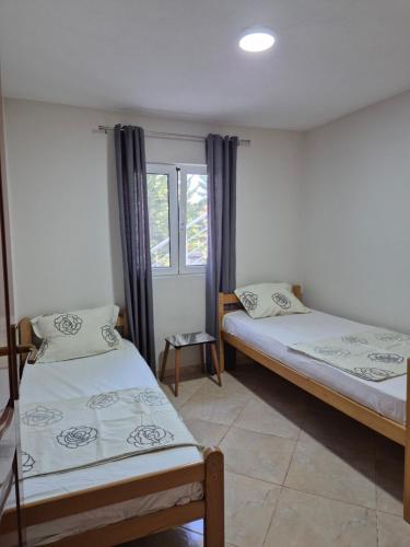 Dos camas en una habitación con ventana. en Apartments Nuro, en Ulcinj