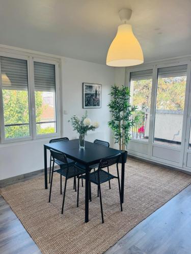 a dining room with a black table and chairs at 1 - Zénith - Parc Expo - Campus - Sud 3 - Diochon in Le Grand-Quevilly