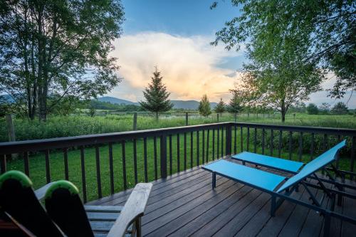 a wooden deck with a bench and a blue table at Panorama Point - Gorgeous views, hot tub, theater in Davis