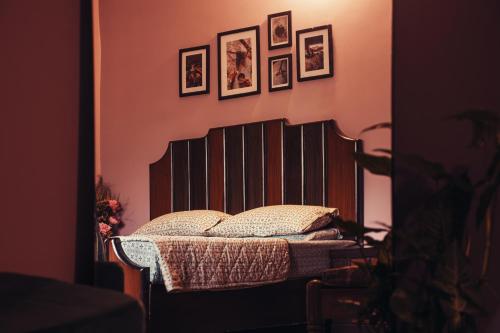 a bed in a room with pictures on the wall at The Mountain Retreat, Muzaffarabad - Families Only in Muzaffarabad