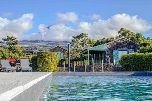 a house with a swimming pool in front of a house at Refúgio da Montanha in Lajido