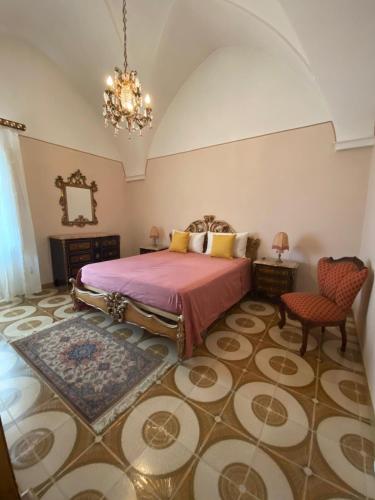 a bedroom with a king sized bed and a chandelier at Palazzotto Romantic in San Michele Salentino