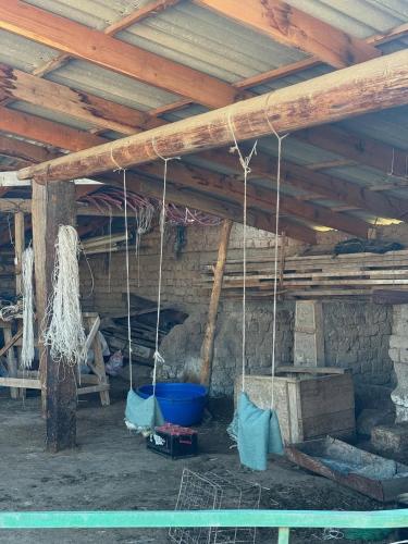 a barn with a wooden ceiling with ropes at Guest House Bektash in Kyzart