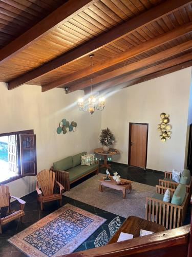 a living room with a green couch and chairs at Pousada Casa Cerrado in Colinas Do Sul