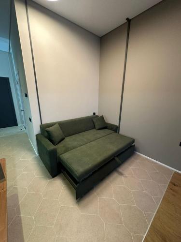 a green couch sitting in a room at Lighthouse 2 studio in Nardaran