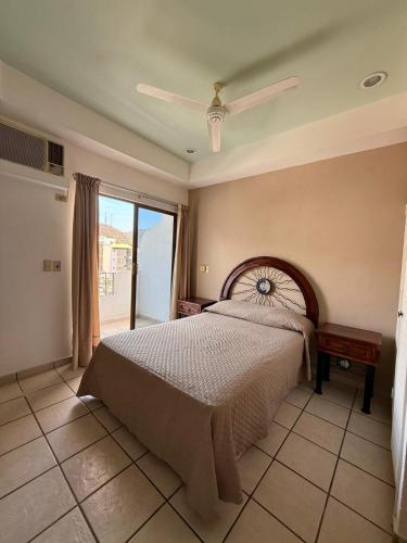 a bedroom with a bed and a large window at Departamento Cielo in Puerto Vallarta