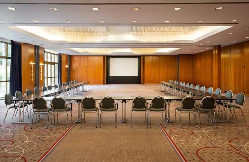 a conference room with a long table and chairs at Leonardo Hotel Weimar in Weimar