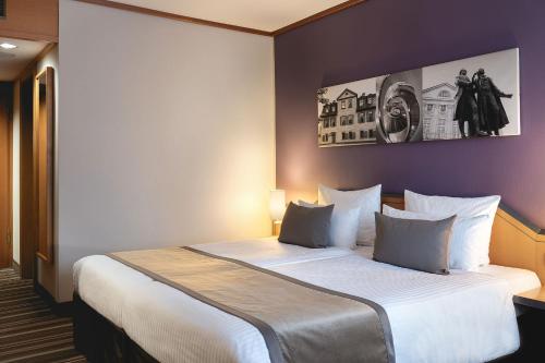 a bedroom with a large bed in a room at Leonardo Hotel Weimar in Weimar