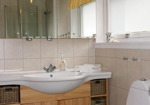 La salle de bains est pourvue d'un lavabo et d'un miroir. dans l'établissement Tustna Ladestasjon, à Hals