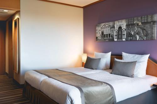 a bedroom with a large bed in a room at Leonardo Hotel Weimar in Weimar