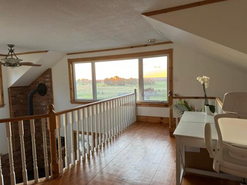 a room with a staircase with a large window at Farmhouse Resort in Midhurst