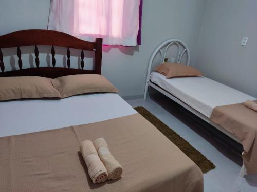 una camera da letto con due letti con asciugamani sopra di Residencial Franco Casa 01 a Primavera do Leste