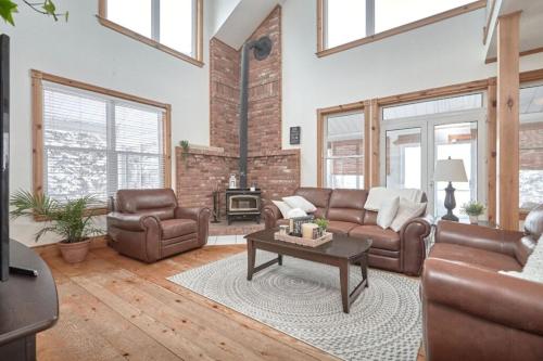 a living room with leather furniture and a fireplace at Farmhouse Resort in Midhurst