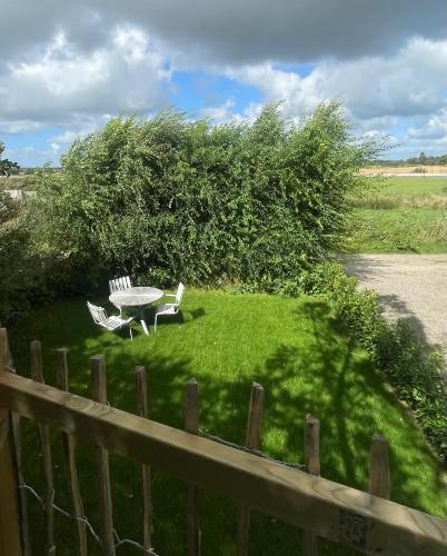 a yard with a table and chairs and a fence at The Nest bed and garden in Varberg