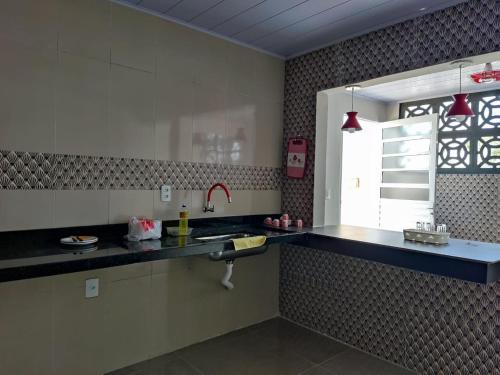 una cucina con bancone e lavandino e una finestra di Residencial Franco Casa 01 a Primavera do Leste