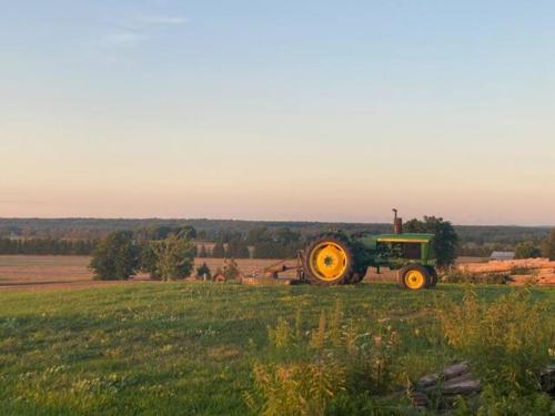 a tractor parked in a field in a field at Farmhouse Resort in Midhurst
