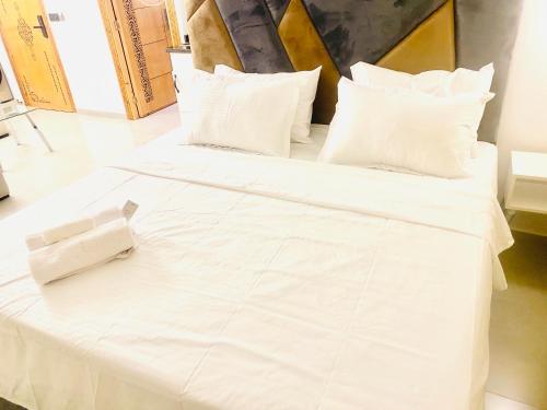two white beds with white sheets and pillows at nouvelle studio climatisé in Fès