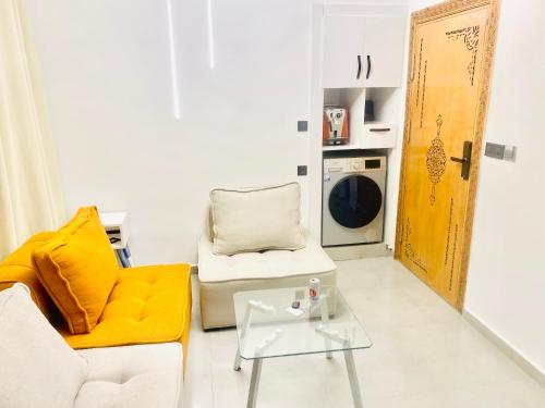 a living room with a couch and a chair and a table at nouvelle studio climatisé in Fès