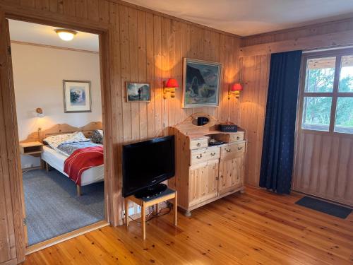 a bedroom with a bed and a flat screen tv at Høvringen Lodge in Høvringen