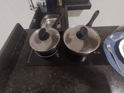 two pots sitting on top of a stove at Loft Marajó in Soure