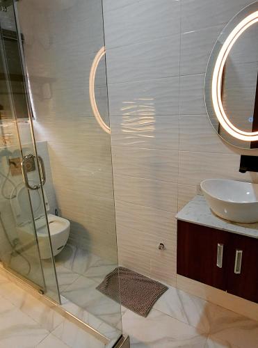 a bathroom with a shower and a sink and a toilet at The Ambassadors Hotel in Lagos