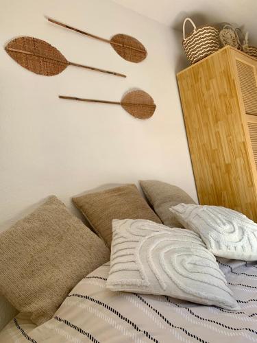 a bed with pillows and a shelf with wooden sticks at Le nid du Piémont in Barr