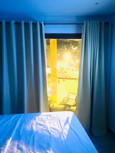 a bedroom with a bed and a window with curtains at nouvelle studio climatisé in Fès