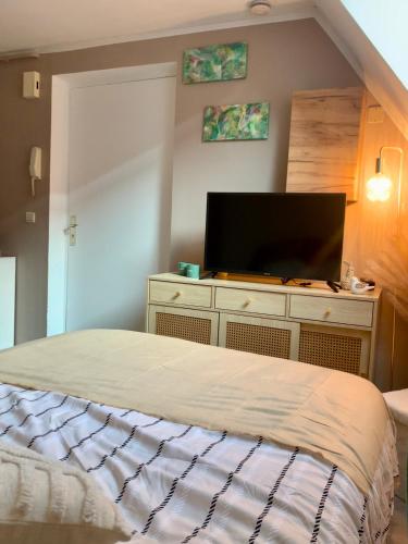 a bedroom with a bed and a flat screen tv at Le nid du Piémont in Barr