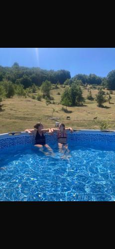two people are sitting in a swimming pool at Jezerina in Šavnik