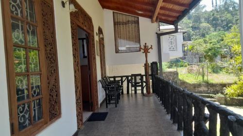 a balcony of a house with chairs and a table at New Cherry Wood Bangalow in Bandarawela