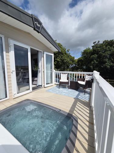 a deck with a hot tub on a house at Rural Retreat Chy Kensa a Hot Tub Haven in Grampound