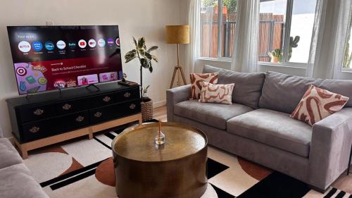 a living room with a couch and a flat screen tv at San Diego Oasis Fire Pit, Putting Green, Near Everything in San Diego