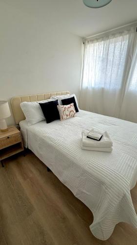 a white bed with two towels on top of it at San Diego Oasis Fire Pit, Putting Green, Near Everything in San Diego