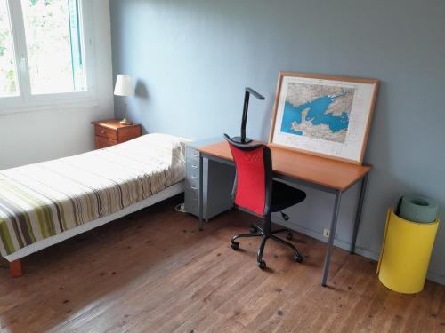 a bedroom with a desk with a bed and a deskictericter at Le calme près de la ville in Saumur