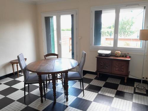 a dining room with a wooden table and chairs at Le calme près de la ville in Saumur