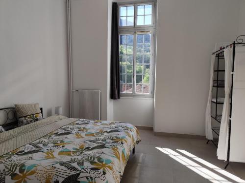a bedroom with a bed and a window at O'Couvent - Appartement 131 - 2 chambres - 90 m2 - Troisième étage in Salins-les-Bains