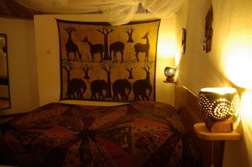 a bedroom with a bed with a tapestry on the wall at Bed and breakfast Keur Niaye in Toubakouta
