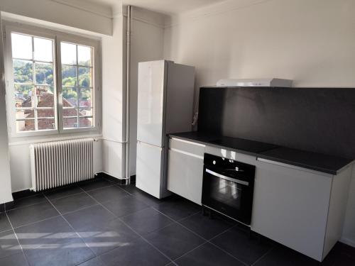 a kitchen with a refrigerator and a microwave at O'Couvent - Appartement 131 - 2 chambres - 90 m2 - Troisième étage in Salins-les-Bains