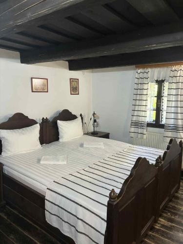 a bedroom with a large bed with white sheets at Hollóköves Vendégházak in Hollókő