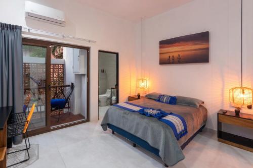 a bedroom with a bed and a view of a bathroom at Makawe in Sayulita