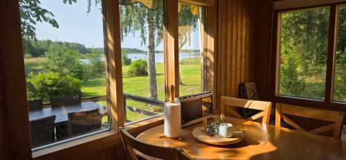 a dining room with a table and a large window at Merenkurkku in Molpe