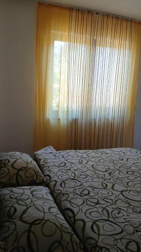 a bedroom with a bed and a window with curtains at Apartment Sunny in Sarajevo