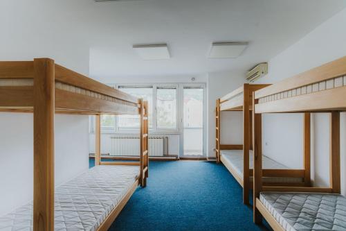 2 Etagenbetten in einem Zimmer mit blauem Teppich in der Unterkunft Hostel Rio in Sarajevo