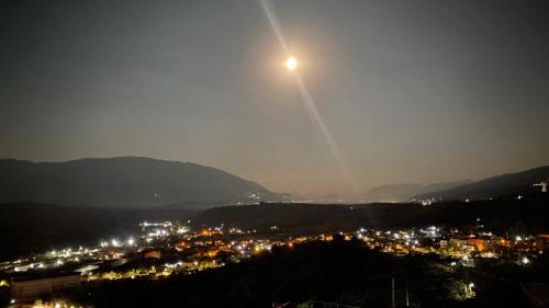 a view of a city at night with the moon at RONDO Guesthouse in Gjirokastër