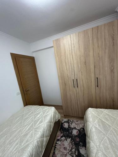 a bedroom with two beds and wooden cabinets at Puka Retreat in Pukë