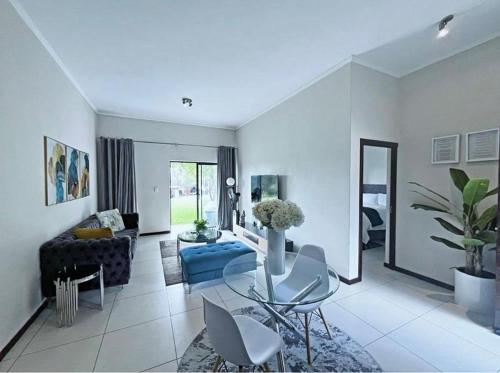 a living room with a couch and a table and chairs at 13 Sunningdale - Jackals Creek Golf Estate in Roodepoort