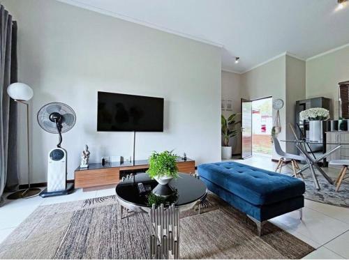 a living room with a blue couch and a table at 13 Sunningdale - Jackals Creek Golf Estate in Roodepoort