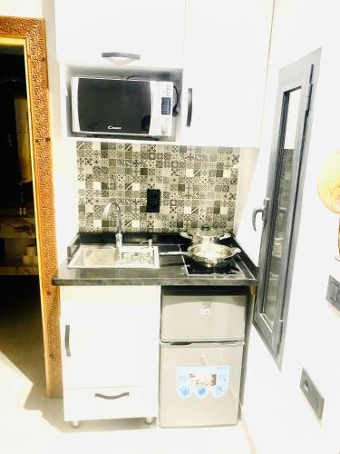 a small kitchen with a sink and a microwave at nouvelle studio climatisé in Fès