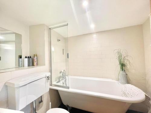 カンタベリーにあるChic 3 Bedroom Flat in Canterbury with Cathedral Viewsの浴槽とトイレのある白いバスルーム